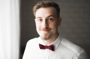 Güzel adam, damat poz veriyor ve düğüne hazırlanıyor..