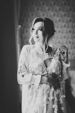 Cüppeli muhteşem gelin bir odada düğün töreni için poz veriyor ve hazırlanıyor..