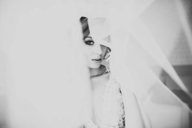 Cüppeli muhteşem gelin bir odada düğün töreni için poz veriyor ve hazırlanıyor..