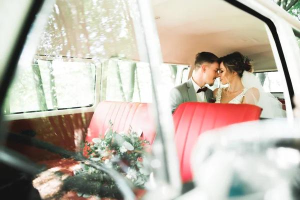 Just married couple in the luxury retro car on their wedding day.