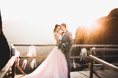 Harika bir gelin damada poz veriyor ve harika manzaralı dağlarda lüks bir tören yapıyor..