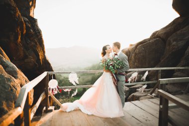 Harika bir gelin damada poz veriyor ve harika manzaralı dağlarda lüks bir tören yapıyor..