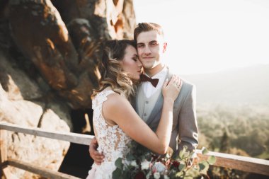 Gün batımında dağ zemin üzerine bir buket ile güzel gelin.