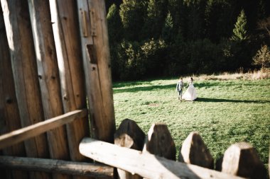 Güzel, romantik bir düğün. Yeni evliler. Eski kalenin yakınlarında sarılıyorlar..