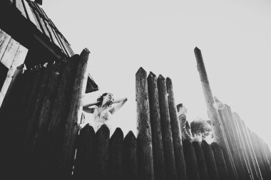 Güzel, romantik bir düğün. Yeni evliler. Eski kalenin yakınlarında sarılıyorlar..