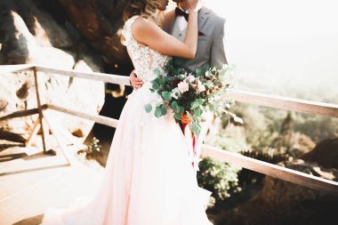 Gün batımında dağ zemin üzerine bir buket ile güzel gelin.