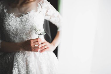 Beyaz elbiseli lüks gelin düğün törenine hazırlanırken poz veriyor..