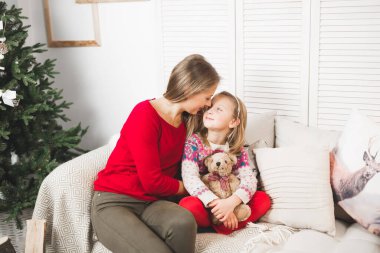 Mutlu Noeller ve mutlu tatiller. Neşeli anne ve tatlı kızı hediye değiş tokuşu yapıyor..