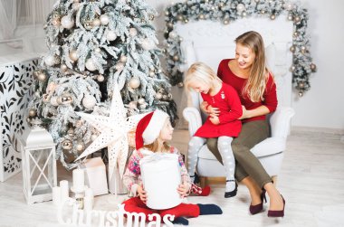 Anne ve kızları küçük kızların doğum günü hediyelerini açıyorlar..