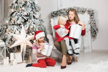 Anne ve kızları küçük kızların doğum günü hediyelerini açıyorlar..