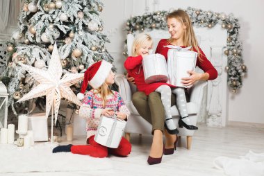 Anne ve çocukları Noel ağacının yanında kutluyorlar..