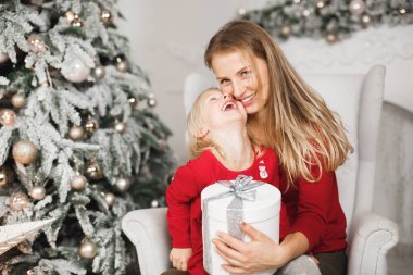 Mutlu Noeller ve mutlu tatiller. Neşeli anne ve tatlı kızı hediye değiş tokuşu yapıyor..
