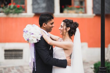 Güzel, mutlu bir düğün çifti, güzel şehirde uzun beyaz elbiseli bir gelin..