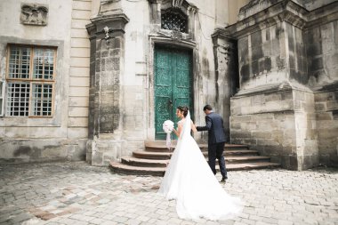 Sevgi dolu bir düğün çifti Lviv şehrinin sokaklarında yürüyor..