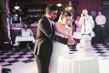 Gelin ve damat düğün pastasını kesiyor..