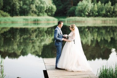 Güzel gelin ve damat evlendikleri gün kucaklaşıp öpüşüyorlar..