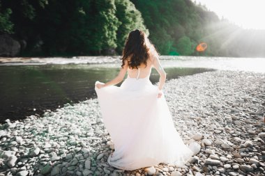 Nehrin kenarında duran uzun saçlı güzel gelinin portresi..