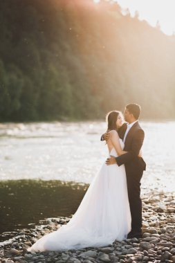 Romantik düğün anı, yeni evli çiftin gülümseyen portresi, gelin ve damadın kucaklaşması.