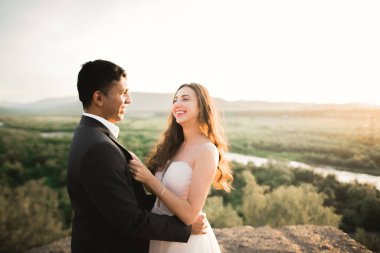 Romantik düğün anı, yeni evli çiftin gülümseyen portresi, gelin ve damadın kucaklaşması.