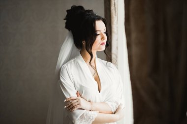 Beyaz elbiseli lüks gelin düğün törenine hazırlanırken poz veriyor..