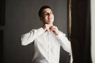 Güzel adam, damat poz veriyor ve düğüne hazırlanıyor..