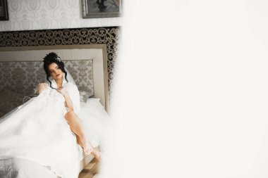 Beyaz elbiseli lüks gelin düğün törenine hazırlanırken poz veriyor..