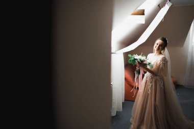 Beyaz elbiseli lüks gelin düğün törenine hazırlanırken poz veriyor..