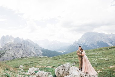 Harika bir gelin damada poz veriyor ve harika manzaralı dağlarda eğleniyor. Mesajlaşacak yer, düğün çifti..