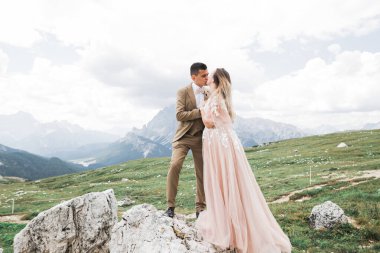 Sadece öpüşen evli bir çift, arka planda dağlar var..