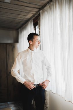 Güzel adam, damat poz veriyor ve düğüne hazırlanıyor..