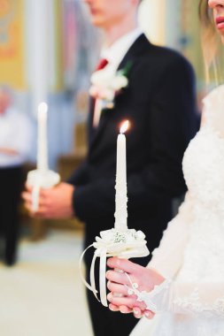 Gelin ve damat kilisede mum tutuyorlar..