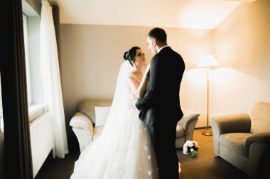 Göz kamaştırıcı mutlu çift birbirine yakın duruyor ve gözlerinin içine bakıyor..