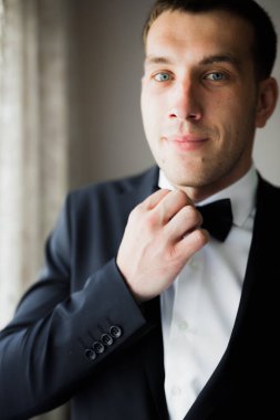 Güzel adam, damat poz veriyor ve düğüne hazırlanıyor..