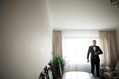 Güzel adam, damat poz veriyor ve düğüne hazırlanıyor..