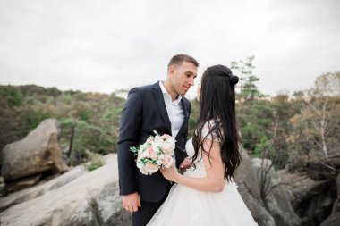 Dağların arka planında sevgi dolu bir koca ve kadın. Sevgili çift duygusal olarak vakit geçirir..