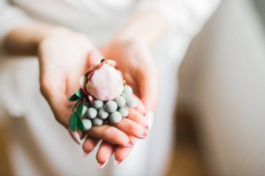 Gelin elinde çiçeklerle güzel bir buket tutuyor.