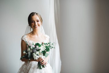 Gelin çiçekli büyük ve güzel bir düğün buketi tutuyor..