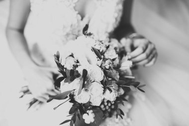 Gelin çiçekli büyük ve güzel bir düğün buketi tutuyor..