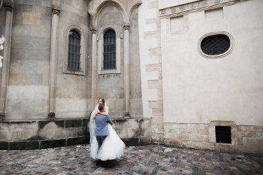 Romantik düğün anı, yeni evli çiftin gülümseyen portresi, gelin ve damadın kucaklaşması.