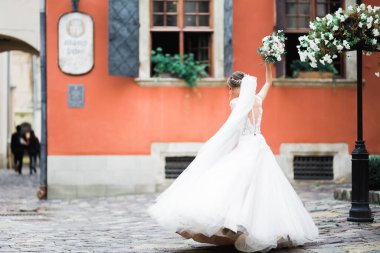 Gelin çiçekli büyük ve güzel bir düğün buketi tutuyor..