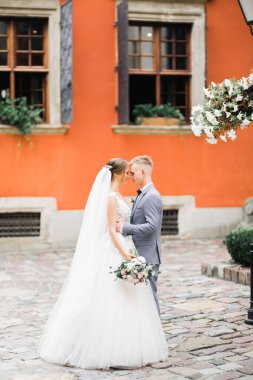 Doğadaki düğün çifti birbirine sarılıyor. Beyaz elbiseli güzel bir kız. Takım elbiseli adam.