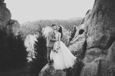 Dağların arka planında sevgi dolu bir koca ve kadın. Sevgili çift duygusal olarak vakit geçirir..