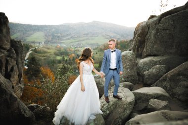 Dağların arka planında sevgi dolu bir koca ve kadın. Sevgili çift duygusal olarak vakit geçirir..