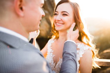 Gün batımında dağ zemin üzerine bir buket ile güzel gelin.