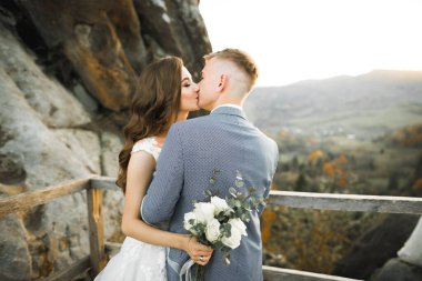 Güzel gelin ve damat evlendikleri gün kucaklaşıp öpüşüyorlar..