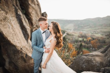 Harika bir gelin damada poz veriyor ve harika manzaralı dağlarda eğleniyor. Mesajlaşacak yer, düğün çifti..