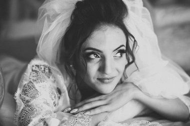 Cüppeli muhteşem gelin bir odada düğün töreni için poz veriyor ve hazırlanıyor..