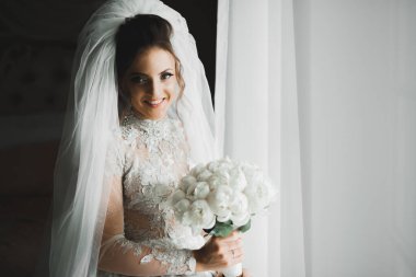 Gelin çiçekli büyük ve güzel bir düğün buketi tutuyor..