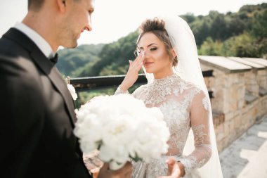 Güzel, genç bir çift ellerinde çiçeklerle poz veriyorlar..