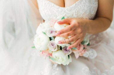 Çekici gelinin portresi, uzun saçlı, büyük buketli poz veren..